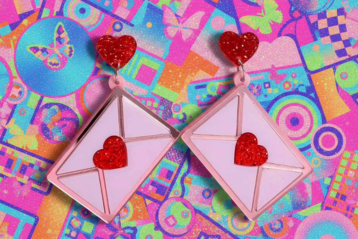 Earrings with heart designs on a pink background